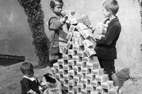 Nur noch Spielgeld: Kinder bauen aus den Scheinen eine Pyramide.
