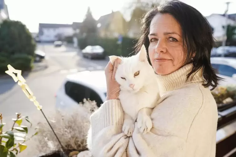 Regine Tredwell mit Katze Fluffy auf dem Balkon ihrer Wohnung.