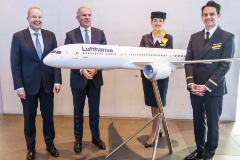 Finanzvorstand Remco Steenbergen (links), Vorstandschef Carsten Spohr und fliegendes Personal stehen neben einem Lufthansa-Flugz