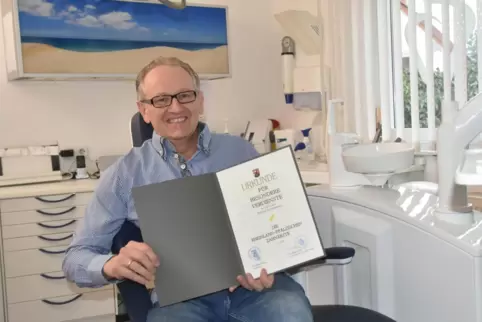 Meinrad Kirchgässner sitzt mal selbst auf dem Behandlungsstuhl. Aber nur fürs Foto mit seiner Auszeichnung. 