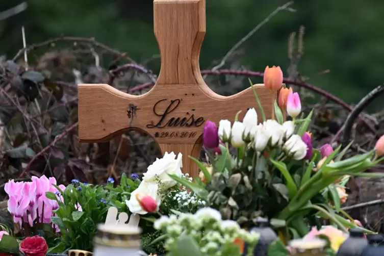 Am Tatort in Freudenberg: ein Holzkreuz, zahlreiche Blumen, Kuscheltiere und Kerzen.
