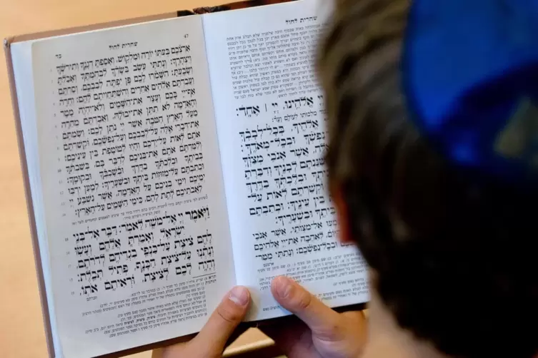 Ein Schüler der Talmud Tora Schule in Hamburg schaut in ein jüdisches Gebetsbuch.