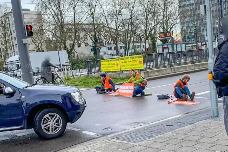 Klima-Aktivisten der Letzten Generation blockieren Straße in Karlsruher Innenstadt . 