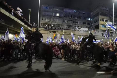  Israelische Polizisten auf Pferden treiben am Samstagabend Demonstranten auseinander, die eine Autobahn blockieren. 