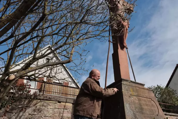 Der Hettenleidelheimer Steinmetz Klaus Rörig erläutert die Sanierung der Christusfigur.