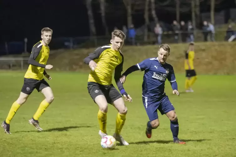  In Lug: Niklas Kempf (in Gelb) im Zweikampf mit Martin Klein von SV Klingenmünster/Göcklingen. Links Paul Fitzthum.