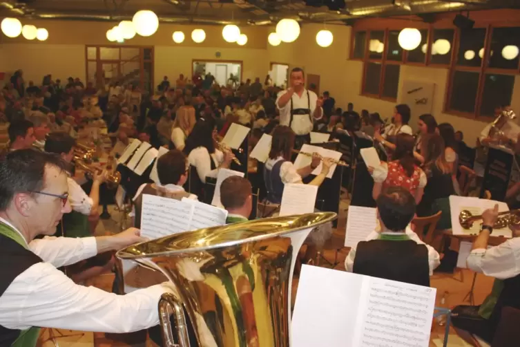 Dirigent Stefan Held (Mitte) mit den Wasgau-Musikanten in der voll besetzten Drachenfels-Halle.