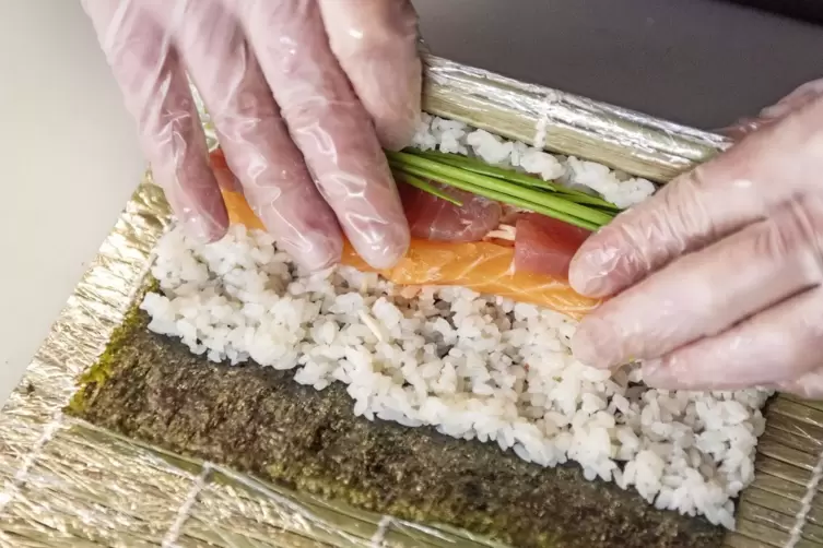 Echte Handarbeit: Das Zubereiten und Rollen von Sushi.