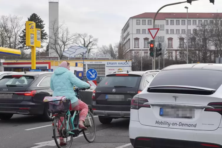 Feierabendverkehr in Neustadt: eine Fahrradfahrerin umgeben von vielen Autos. 