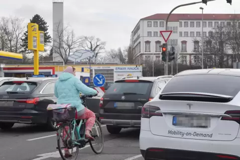 Feierabendverkehr in Neustadt: eine Fahrradfahrerin umgeben von vielen Autos. 