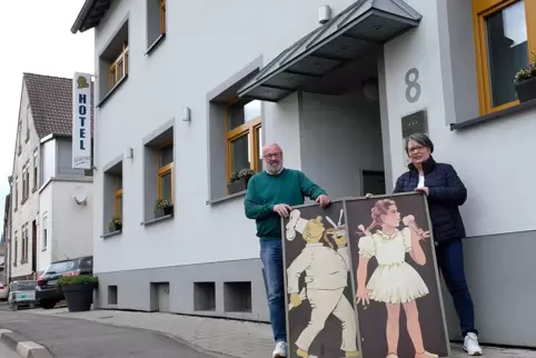 Wolfgang und Denise Brünnler stehen mit alten Werbeschildern aus den 60ern vor ihrem Hotel, das sie im April schließen mussten. 