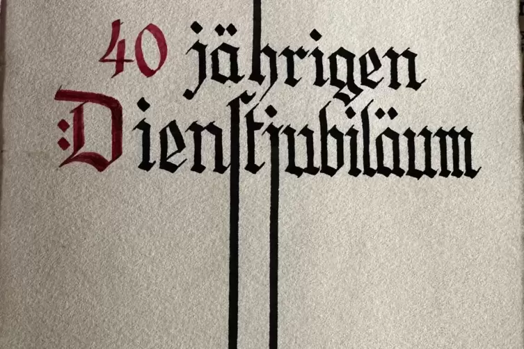 Eine Mitarbeiter-Ehrungskarte von 1940. „Die besten Wünsche zum 40. Dienstjubiläum“, steht in altdeutscher Schrift darauf. Knapp