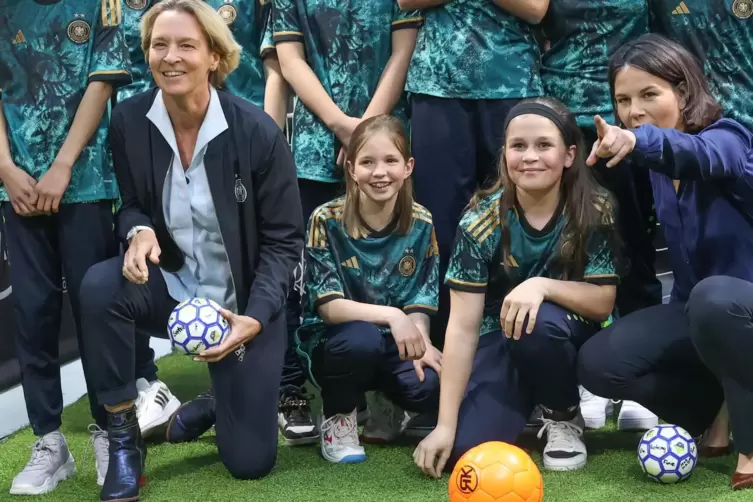 Annalena Baerbock (rechts) und Bundestrainerin Martina Voss-Tecklenburg mit jungen Fußballerinnen des SC Siemensstadt.