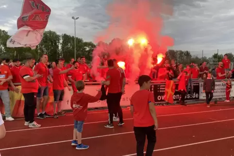 Nach dem Schlusspfiff: rotes Feuerwerk der Niederkirchener Anhänger, die ihre Mannschaft feiern.