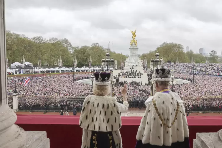 Gruß der Gekrönten: König Charles III. und Königin Camilla winken vom vom Balkon des Buckingham Palace aus der Menge. 