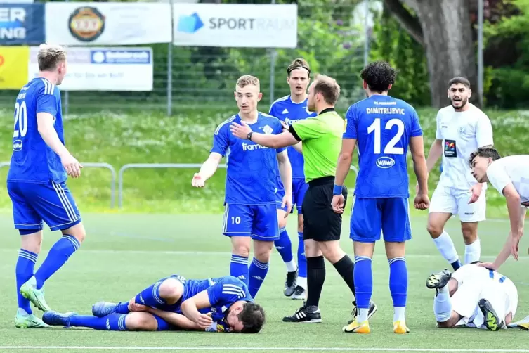FKP-Kapitän David Becker (in Blau) liegt – ebenso wie der Gonsenheimer Mehmet Yildiz – am Boden, seine Mitspieler (von links) De