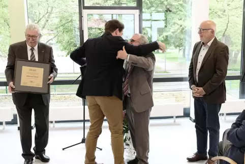 Von links: Awo-Ehrenvorsitzender Klaus Stalter, Präsidiumsvorsitzender Thomas Hitschler umarmt Ehrenmitglied Wilhelm Zeiser. Rec