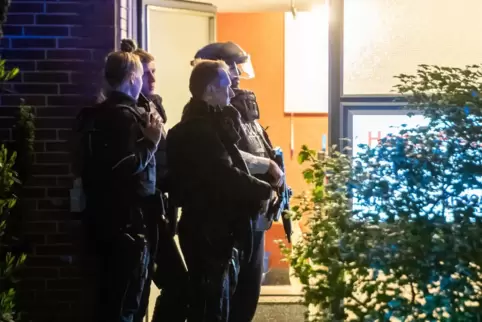  Bewaffnete Polizisten stehen an einer Haustür in Herten. 
