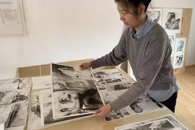 Wu Jiaying mit ihren Arbeiten, die an Gewässern rund um Obermoschel entstanden sind. 