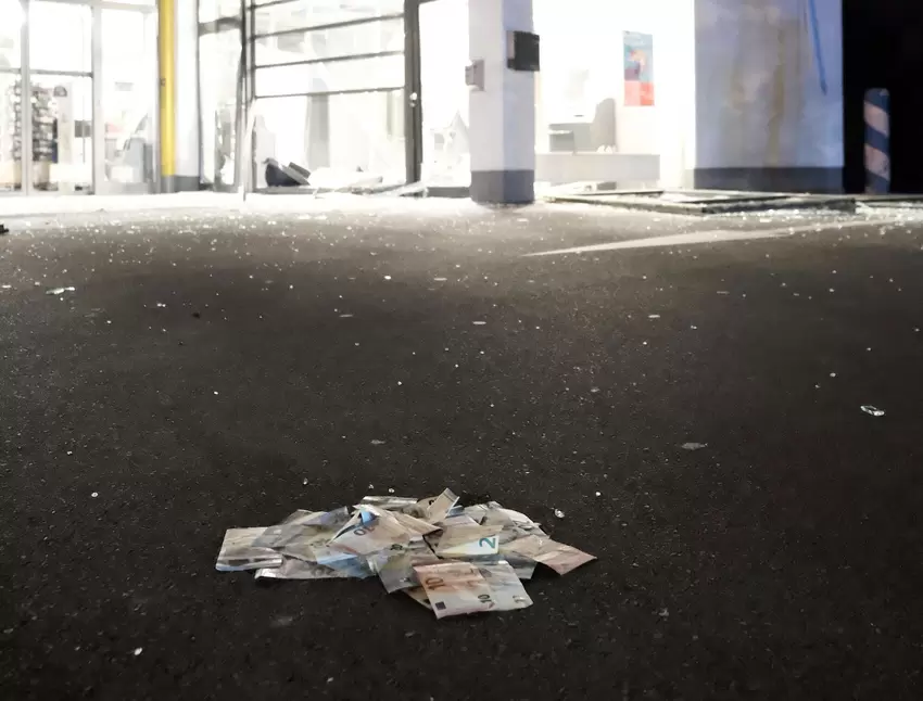 Ein Feuerwehrmann hat einige Geldscheine eingesammelt und zu einem Häufchen zusammengelegt.