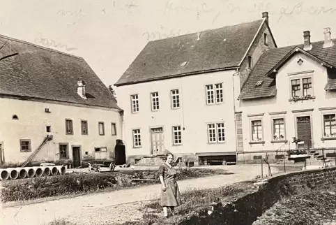 Die Schrollbacher Mühle um 1925. Auf dem Bild ist Adelheid Willenbacher zu sehen, die Tochter des damaligen Mühlenbesitzers. 