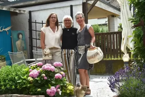 Die drei Künstlerinnen im Garten, in dem sie ihre eigene kleine Kunstmesse inszenieren. 