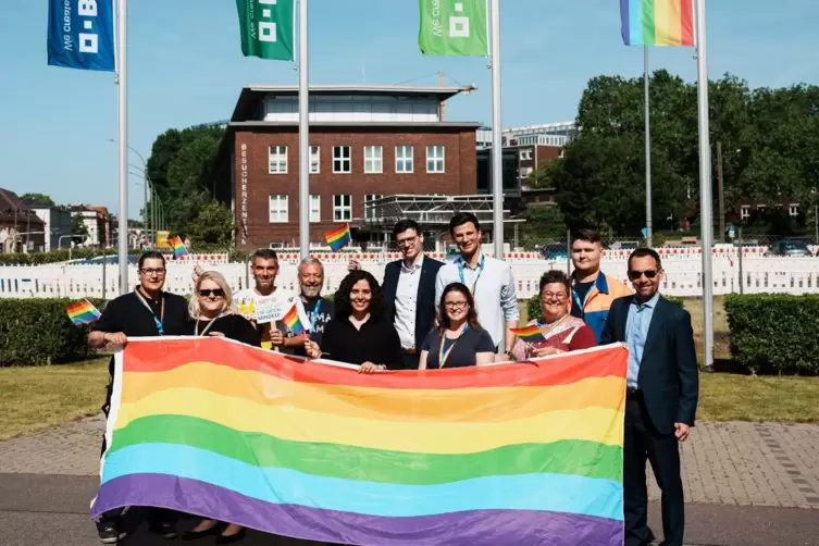 Matthew Lepore (rechts) und Vertreter des Netzwerks LGBT+Friends zeigen am Stammwerk Flagge.