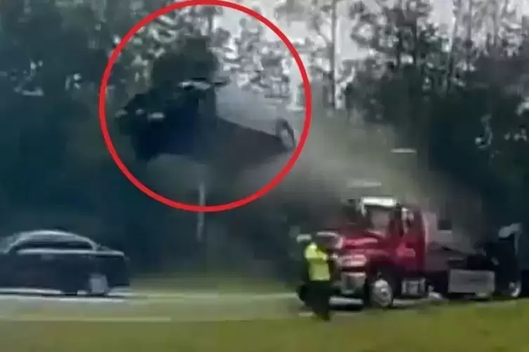 Das Auto im Abflug. Der Mann in Gelb, der zum Abschleppwagen gehört, überlebte den Unfall unverletzt, denn das Auto flog über se