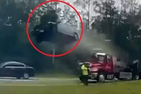 Das Auto im Abflug. Der Mann in Gelb, der zum Abschleppwagen gehört, überlebte den Unfall unverletzt, denn das Auto flog über se