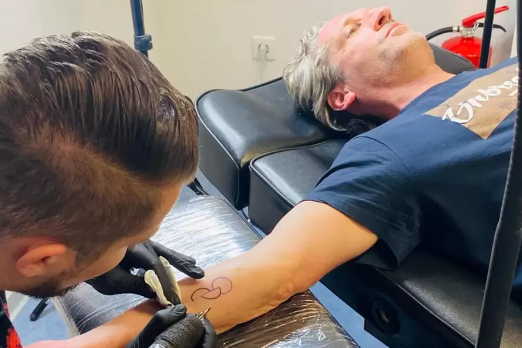 Fast fertig: Steffen Gall (rechts) aus Neustadt tr&auml;gt das Organspende-Tattoo am rechten Unterarm. 