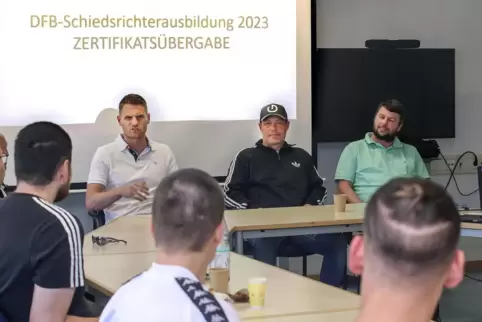 Schiedsrichter Timo Gerach, FCK-Idol Axel Roos und Obmann Jens Schmidt (von links) mit Inhaftierten der JSA Schifferstadt.
