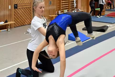  Trainerin Laetitia Waldenberger übt mit Elise einen Flickflack auf der Matte (Bodenturnen).