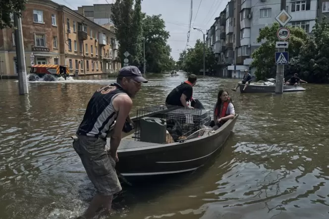 Cherson: Menschen mit Haustieren werden mit einem Boot aus einem überfluteten Stadtteil evakuiert.