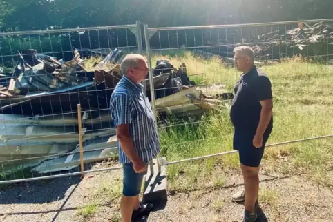 Die Reste der abgebrannten Hütte werden in den kommenden Wochen abtransportiert: PWV-Vorsitzender Gerd Adam (links) und Allianz-