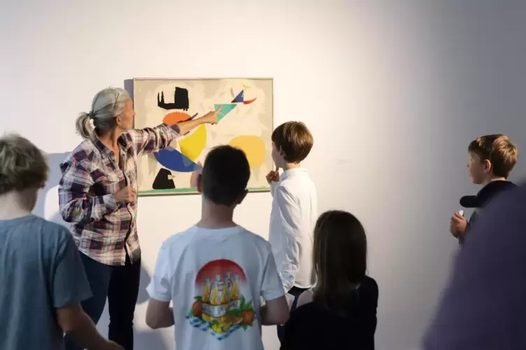 Auf Entdeckungsreise in der Kunst: Ein Mitarbeiter erklärt Kindern ein Werk von Willi Baumeister. 