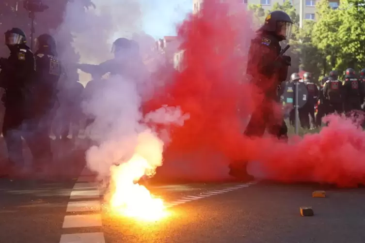 Bei Protesten gegen das Urteil im Prozess gegen Lina E. in Leipzig stehen Polizisten in roten Qualm, nachdem linke Demonstranten