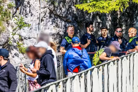 Polizisten und Passanten stehen an der Marienbrücke an einer Absperrung