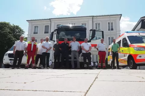 ASB- und DRK-Helfer auf dem Herzogplatz vor den drei neuen Fahrzeugen, die bei Katastrophen zum Einsatz kommen sollen. 