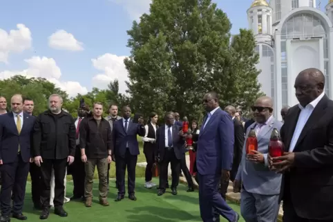 Südafrikas Präsident Ramaphosa (rechts) und seine Delegation bei einer Gedenkzeremonie an einem Massengrab in Butscha. 