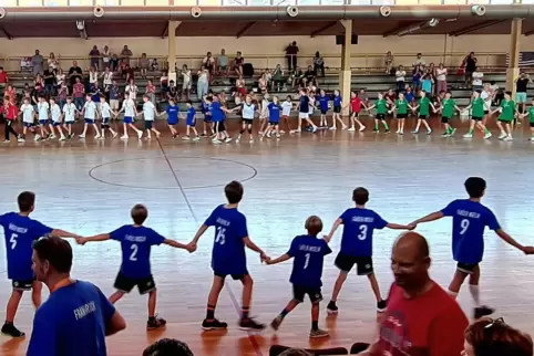 Alle Teams fassen sich bei den Händen bei der Schlusszeremonie der Handball-Mini-WM in Haßloch. 