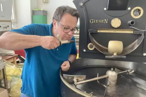 Frank Huber kontrolliert an der Röstmaschine das Ergebnis des Röstvorgangs. 