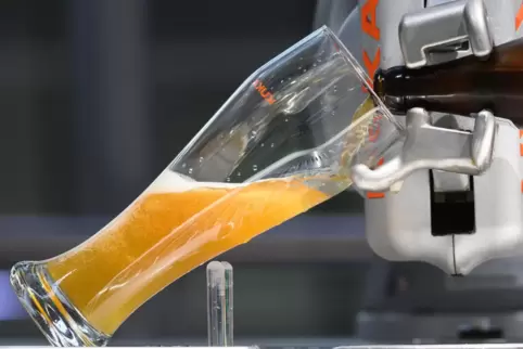 Ein Roboter schenkt ein Glas Hefeweizen ein.