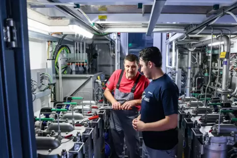 Karsten Viehweger, Schichtleiter der Linamar Antriebstechnik GmbH, und Zakaria Raffali, ein Mitarbeiter aus Marokko, prüfen die 