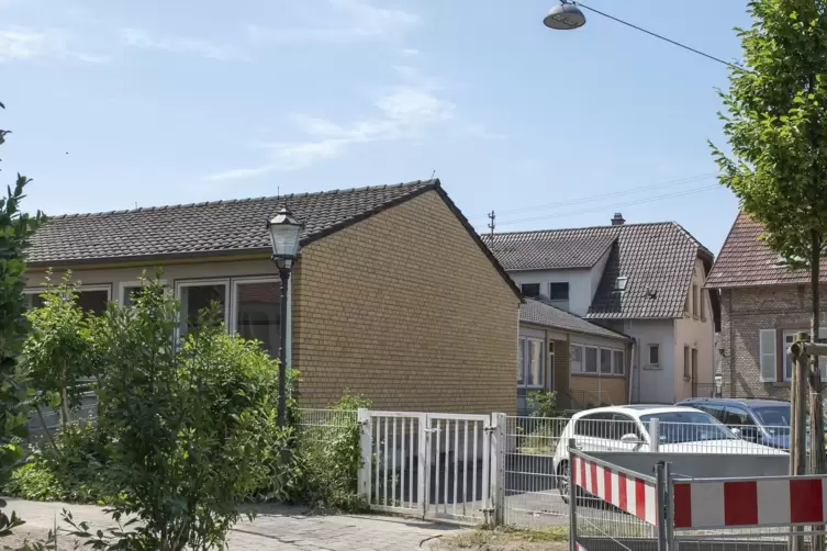 Das Pfarrzentrum aus gelben Ziegelsteinen (links) steht als R&uuml;ckgeb&auml;ude zwischen dem ehemaligen Pfarrheim und der Kirche. 