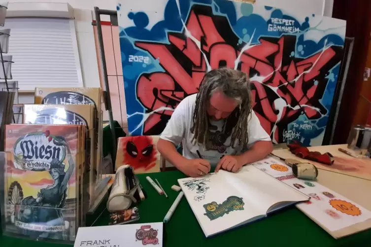 Frank Cmuchal beim Signieren mit Zeichnung.