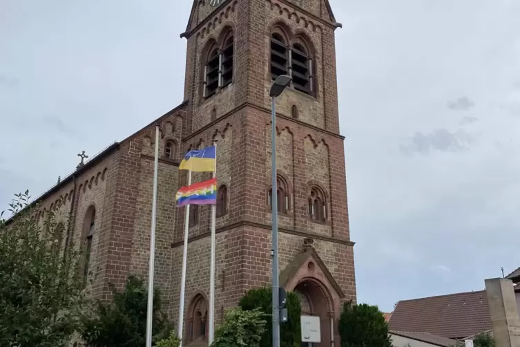 Vor der St. Laurentius Kirche in Bobenheim wehen die ukrainische und eine Regenbogenflagge. Beide mit Friedensbotschaften verseh