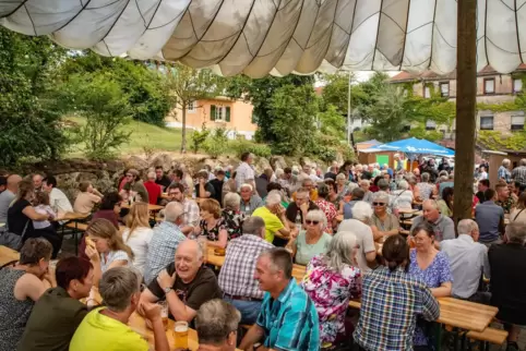 Festbesucher beim sonntäglichen Mittagessen mit Flammkuchen, Grillgut und halben Hähnchen.