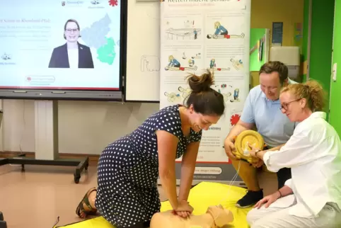 Lehrerin Katharina Dausch (links) übt an der Puppe zuammen mit Notfalltrainer Johannes Peter und ihrer Kollegin Antje Mann.