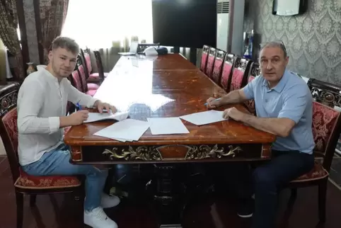 Am großen Tisch: Kimi Merk (links) bei der Vertragsunterschrift in Taschkent.