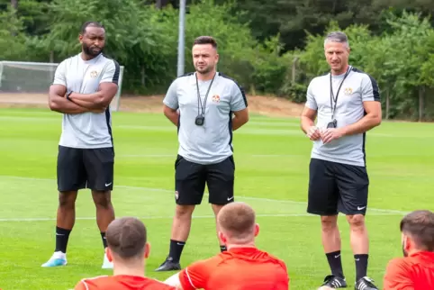  Cheftrainer Alexander Bugera, Co-Trainer Nicola Karl und Athletiktrainer John Malanga (von rechts) bei einer Ansprache vor dem 